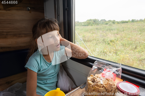 Image of Girl sitting in a reserved seat yawning car looks out the window