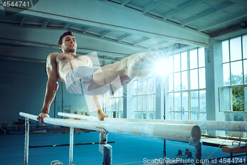 Image of The sportsman during difficult exercise, sports gymnastics