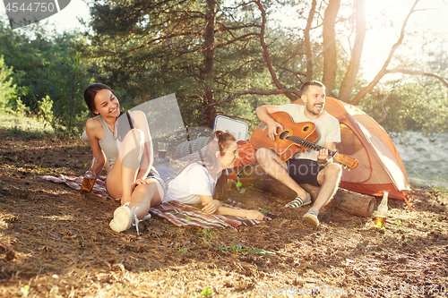 Image of Party, camping of men and women group at forest. They relaxing, singing a song