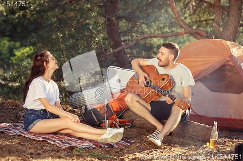 Image of Party, camping of men and women group at forest. They relaxing, singing a song