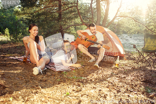 Image of Party, camping of men and women group at forest. They relaxing, singing a song