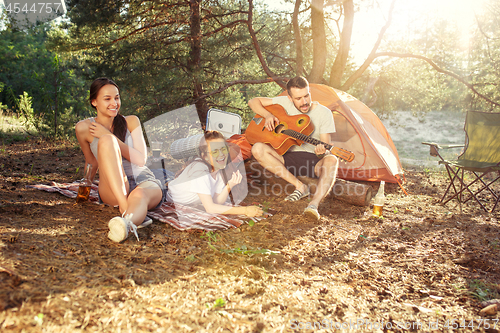 Image of Party, camping of men and women group at forest. They relaxing, singing a song