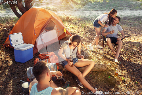 Image of Party, camping of men and women group at forest. They relaxing, singing a song and cooking barbecue