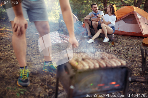 Image of Party, camping of men and women group at forest. They relaxing, singing a song and cooking barbecue