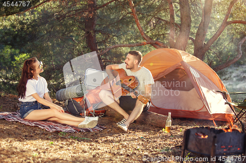 Image of Party, camping of men and women group at forest. They relaxing, singing a song