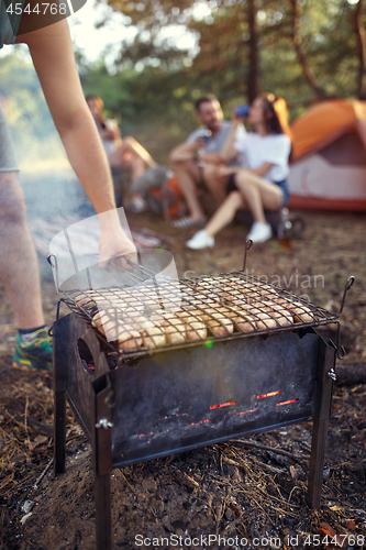 Image of Party, camping of men and women group at forest. They relaxing, singing a song and cooking barbecue