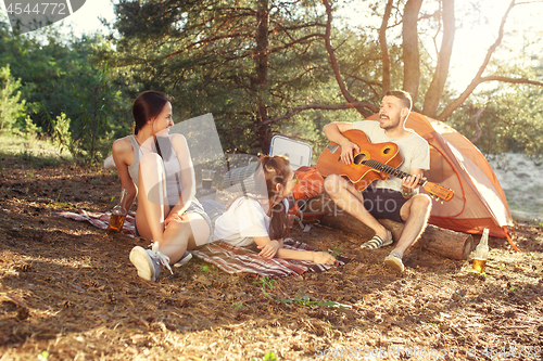 Image of Party, camping of men and women group at forest. They relaxing, singing a song