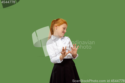 Image of Doubtful pensive teen girl rejecting something against green background