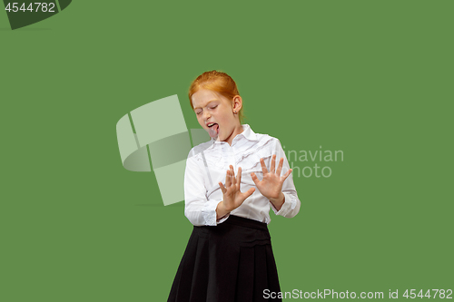 Image of Doubtful pensive teen girl rejecting something against green background
