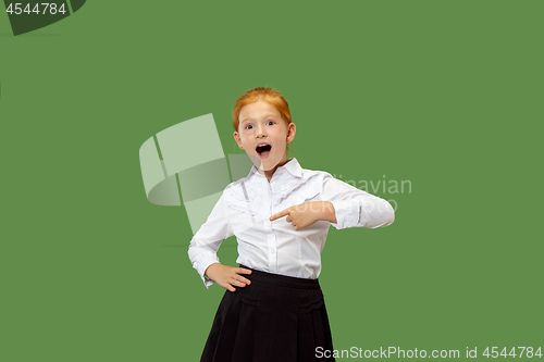 Image of Beautiful teen girl looking suprised isolated on green