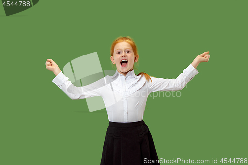 Image of The happy teen girl standing and smiling against green background.