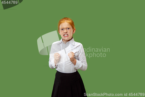 Image of Portrait of angry teen girl on a green studio background