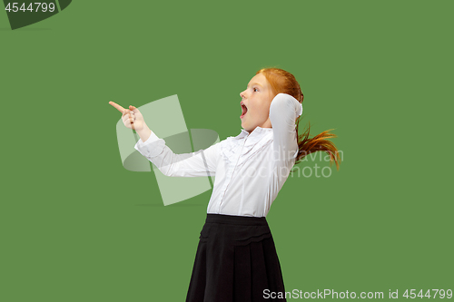 Image of Beautiful teen girl looking suprised isolated on green