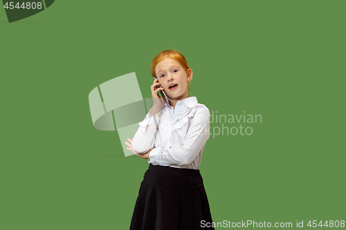 Image of The happy teen girl standing and smiling against green background.