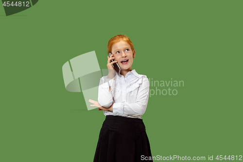Image of The happy teen girl standing and smiling against green background.