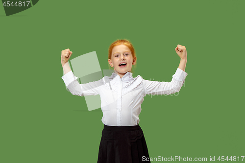 Image of The happy teen girl standing and smiling against green background.