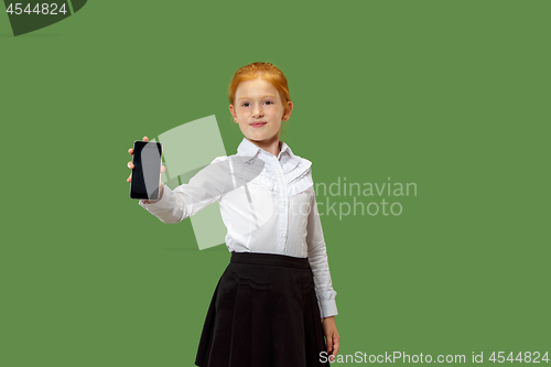 Image of The happy teen girl standing and smiling against green background.