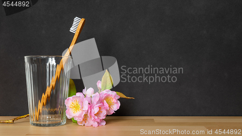Image of a wooden toothbrush in a glass on black background