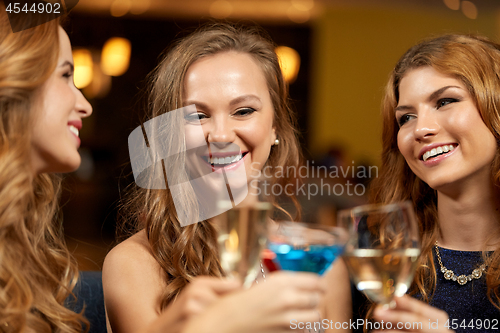 Image of happy women clinking glasses at night club