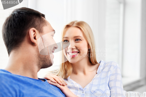 Image of happy couple looking at each other at home