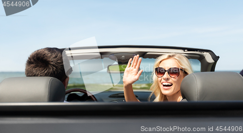 Image of happy man and woman driving in cabriolet car