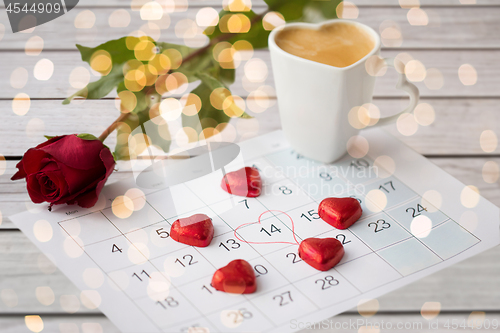 Image of close up of calendar, hearts, coffee and red rose