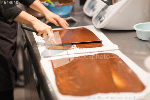 Image of confectioner makes chocolate dessert at sweet-shop