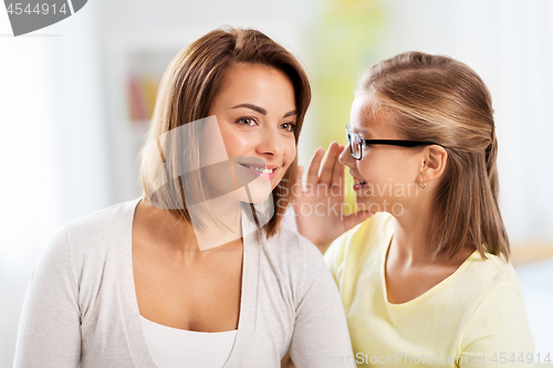 Image of happy daughter whispering secret to her mother