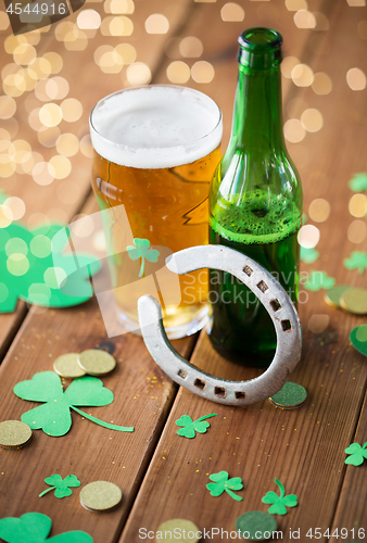 Image of glass of beer, bottle, horseshoe and gold coins