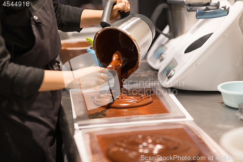 Image of confectioner makes chocolate dessert at sweet-shop