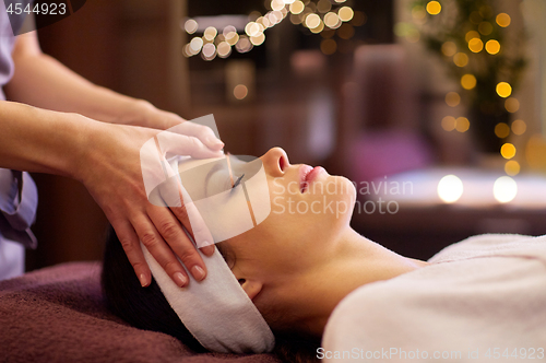 Image of woman having face and head massage at spa