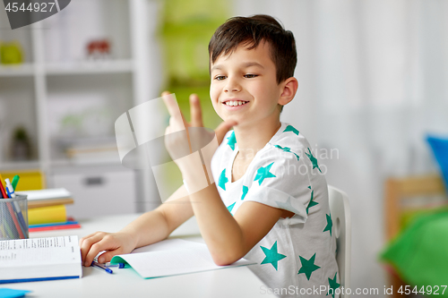 Image of boy doing homework and counting using fingers