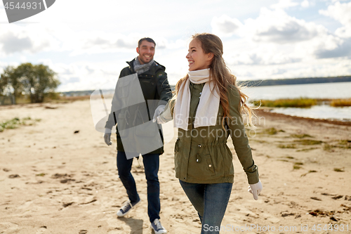 Image of couple walking along autumn beach