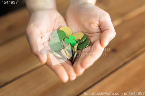 Image of hands with golden coins and shamrock leaf