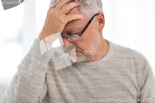 Image of senior man suffering from headache at home