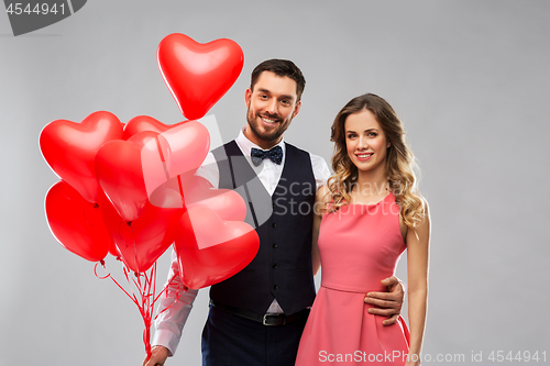 Image of happy couple with red heart shaped balloons