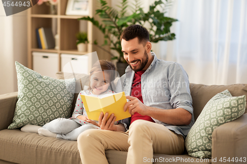Image of happy father and daughter reading book at home