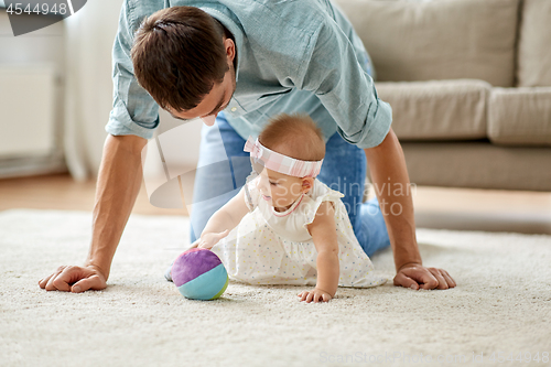 Image of father and little baby daughter with ball at home