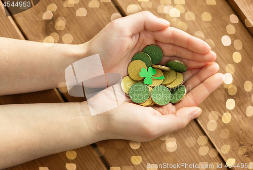 Image of hands with golden coins and shamrock leaf