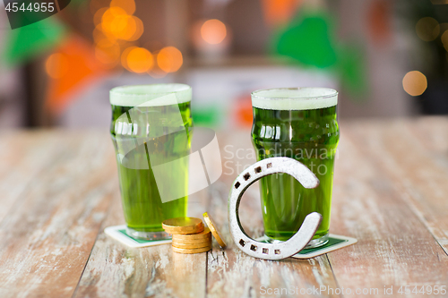 Image of glasses of green beer, horseshoe and gold coins