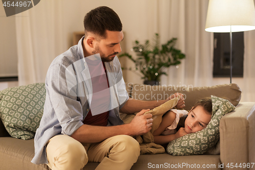 Image of father taking care of ill daughter at home