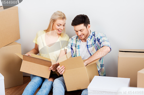 Image of happy couple unpacking boxes at new home