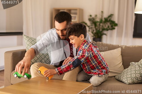 Image of father and son playing with toy cars at home