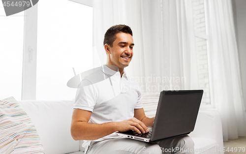 Image of happy man with laptop computer at home