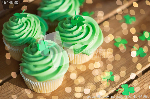 Image of green cupcakes and shamrock on wooden table