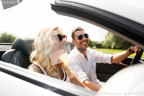 Image of happy man and woman driving in cabriolet car