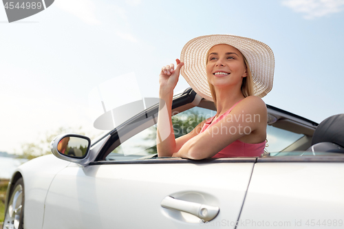 Image of happy young woman in convertible car