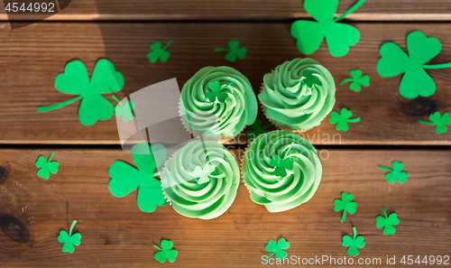 Image of green cupcakes and shamrock on wooden table