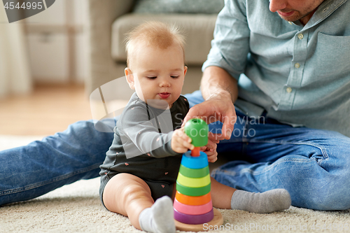 Image of father playing with little baby daughter at home