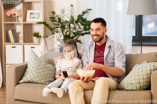 Image of happy father and daughter watching tv at home